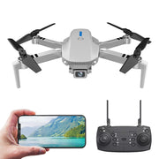 Drone with remote control and smartphone displaying a scenic photo on a white background