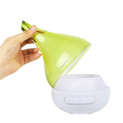 Hand holding a green and white lamp with a brand logo on a white background