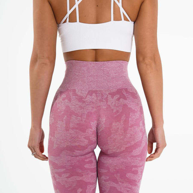 Back view of woman in pink yoga leggings and white sports bra, showcasing style and fit for comfort and flexibility.