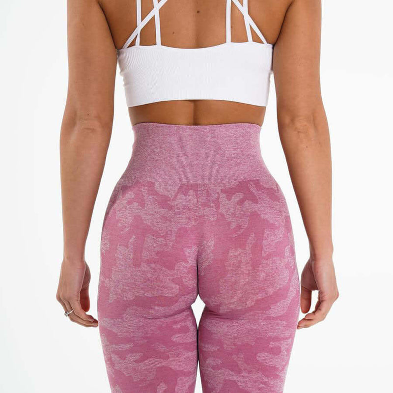 Back view of woman in pink yoga leggings and white sports bra, showcasing style and fit for comfort and flexibility.