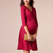 Woman wearing a red dress holding a gold clutch against a beige background