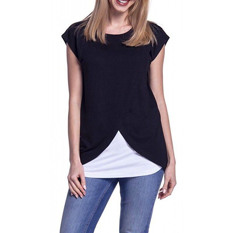 Woman wearing a black cap sleeve top with a white underlayer and blue jeans on a white background