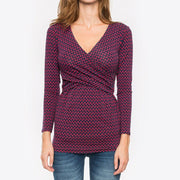 Woman wearing a patterned long-sleeve top on a white background