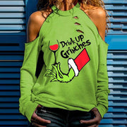 Person wearing a green sweatshirt with 'Drink Up Grinches' text and graphic design.