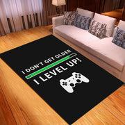 Black rug with gaming-themed design featuring text and a controller on a wooden floor.
