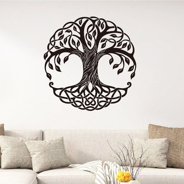 Decorative wall sticker of a tree design on a white wall above a sofa.