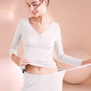 Woman wearing a white ribbed long-sleeve top and pants on a beige background