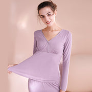 Woman wearing a light purple long-sleeve top against a beige background