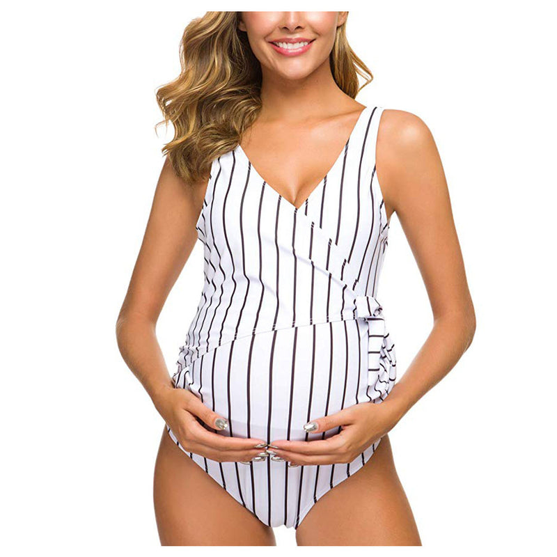 Woman wearing a black and white striped swimsuit on a white background