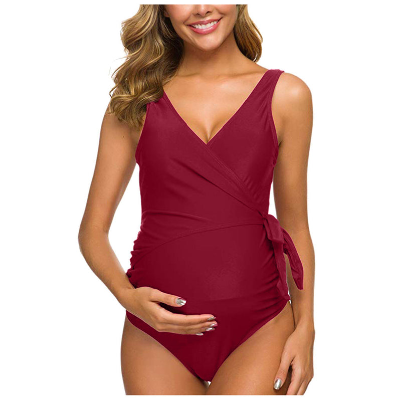 Woman wearing a burgundy one-piece swimsuit on a white background