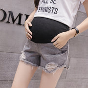 Person wearing a white t-shirt with text and black shorts against a gray background