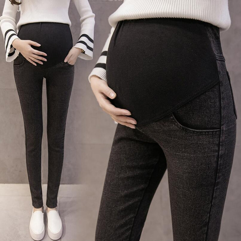 Black maternity pants worn by a person on a gray background
