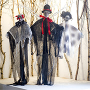 Three ghostly figures in costumes standing in a snowy landscape with bare trees.