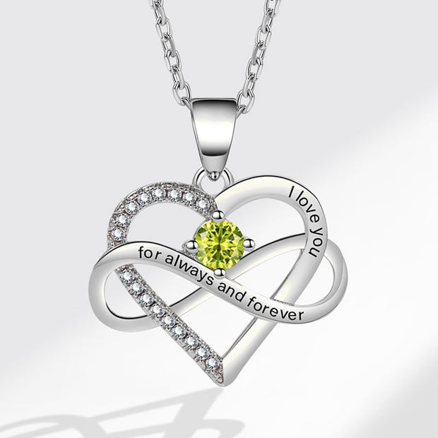 Silver heart-shaped pendant with a green gemstone and 'I love you' engraving on a white background