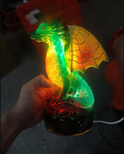 Colorful dragon-shaped lamp held by a hand in a dark setting