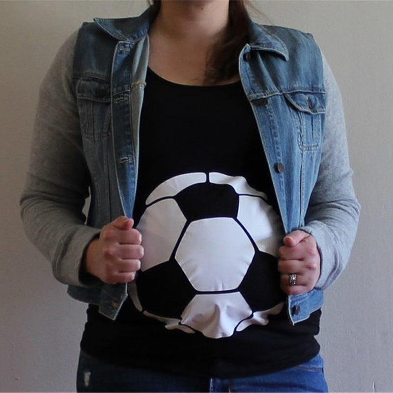 Person wearing a black shirt with a soccer ball design, paired with a denim vest and gray sweater.