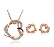 Rose gold heart-shaped jewelry set with necklace and earrings on a white background