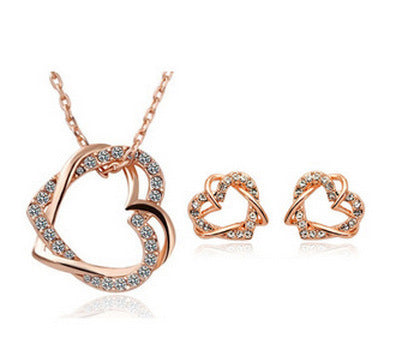 Rose gold heart-shaped jewelry set with necklace and earrings on a white background