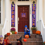 Children in Halloween costumes on a front porch with decorative banners and pumpkins.