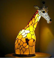 Giraffe-shaped stained glass lamp on a dark background