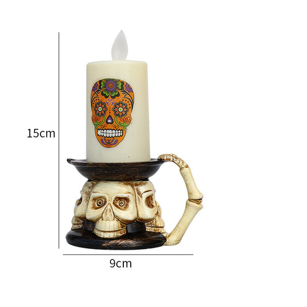 Decorative skull candle holder with a lit candle featuring a colorful skull design, measurements indicated.