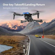 Drone flying over a scenic landscape with mountains and a road.