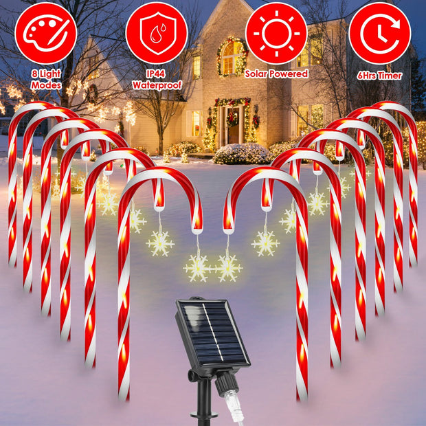 Candy cane-shaped outdoor lights with solar panel in front of a house during Christmas.