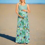 Woman wearing a floral maternity dress on a white background