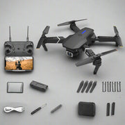 Black drone with remote control, battery, and accessories on a white background