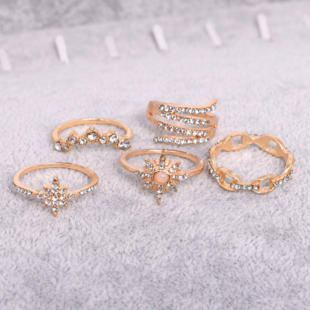 Set of rose gold rings with gemstones on a light gray background
