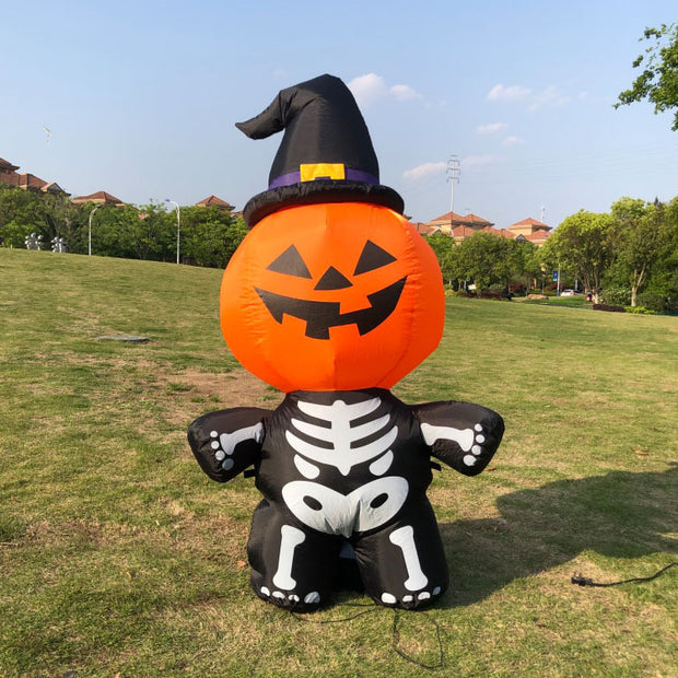 Halloween inflatable decoration with pumpkin face, witch hat, and skeleton body on grass