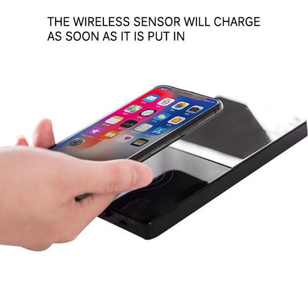 Hand placing a smartphone on a wireless charging pad with text indicating charging capability.