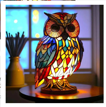 Colorful owl-shaped lamp with stained glass design on a table.