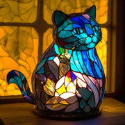 Stained glass cat-shaped lamp with colorful design on a blurred background