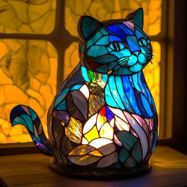 Stained glass cat-shaped lamp with colorful design on a blurred background