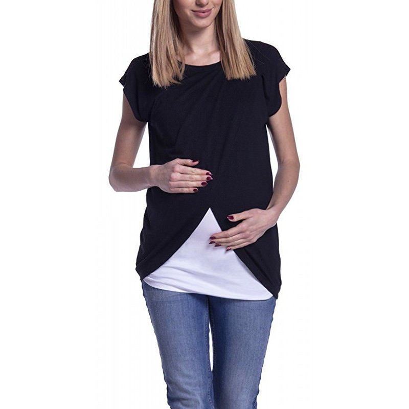 Woman wearing a black cap-sleeve top over a white shirt with blue jeans on a white background