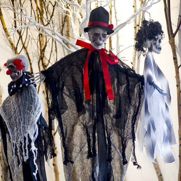 Halloween decorations featuring skeletons in costumes against a snowy background