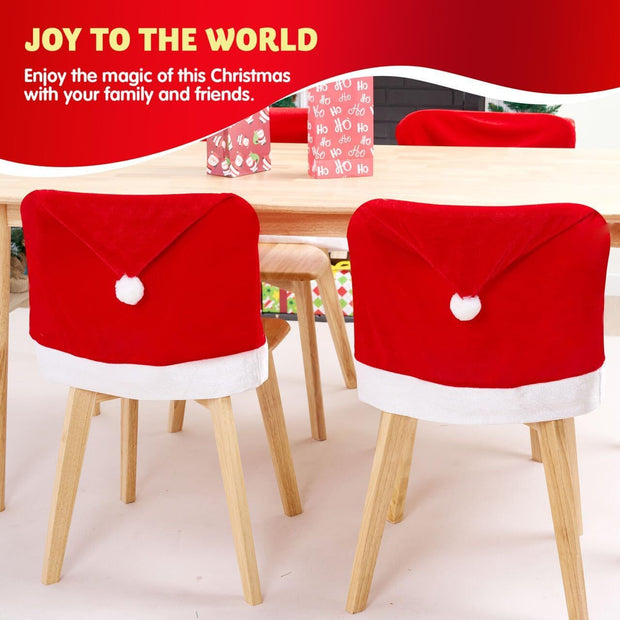 Two chairs with Santa hats on a table with Christmas decorations.