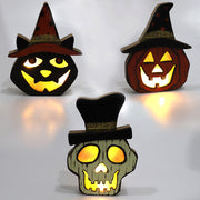 Three Halloween-themed light-up decorations with glowing faces on a white background