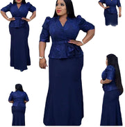 Woman wearing a blue outfit with ruffled top and long skirt on a white background