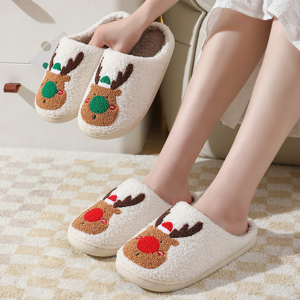 Reindeer-themed slippers worn indoors on a checkered floor.