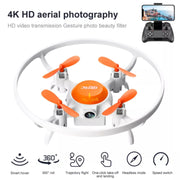 Small drone with orange propellers and white body, accompanied by a remote control and text about aerial photography features.