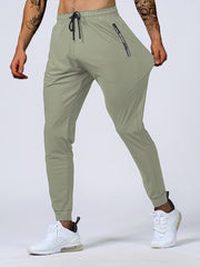 Person wearing olive green jogger pants with a plain background