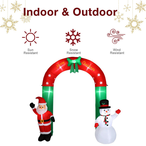 Inflatable Christmas arch with Santa and snowman decorations, featuring text 'Indoor & Outdoor' and icons indicating sun, snow, and wind resistance.