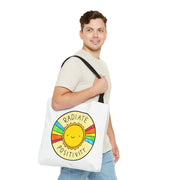 Man holding a tote bag with a sun design and 'Radiate Positivity' text on a white background