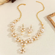 Pearl necklace and earrings set on a beige surface
