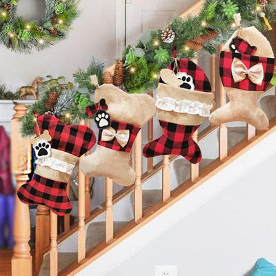 Decorative stockings with plaid patterns and paw prints hanging on a staircase.