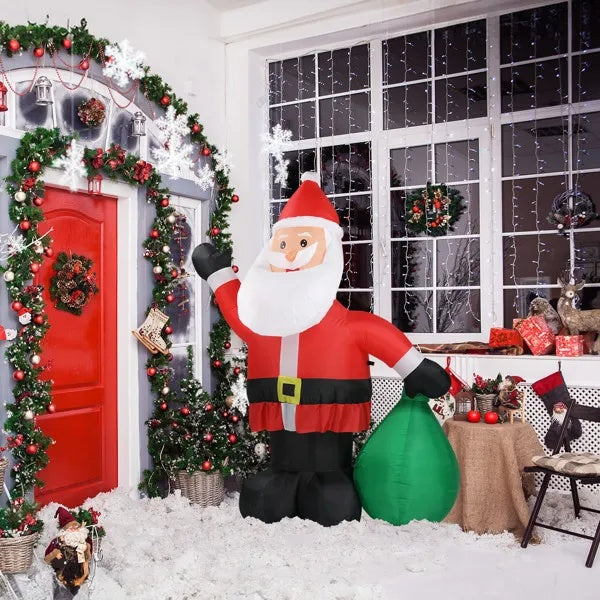 Inflatable Santa Claus decoration in a festively decorated room with Christmas trees and lights.