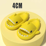 Fun yellow cartoon shark slippers on a yellow platform, designed for comfort and playful style.