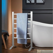 White towel rack with a blue towel hanging on it next to a white bathtub in a bathroom.